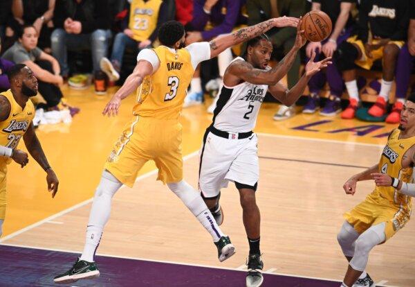 Los Angeles Lakers forward Anthony Davis (centre L) defends against Los Angeles Clippers forward Kawhi Leonard (centre R) during a Christmas Day National Basketball Association (NBA) match-up between the Los Angeles Clippers and Los Angeles Lakers at the Staples Center in Los Angeles, Calif., on Dec. 25, 2019. (Robyn Beck/AFP via Getty Images)