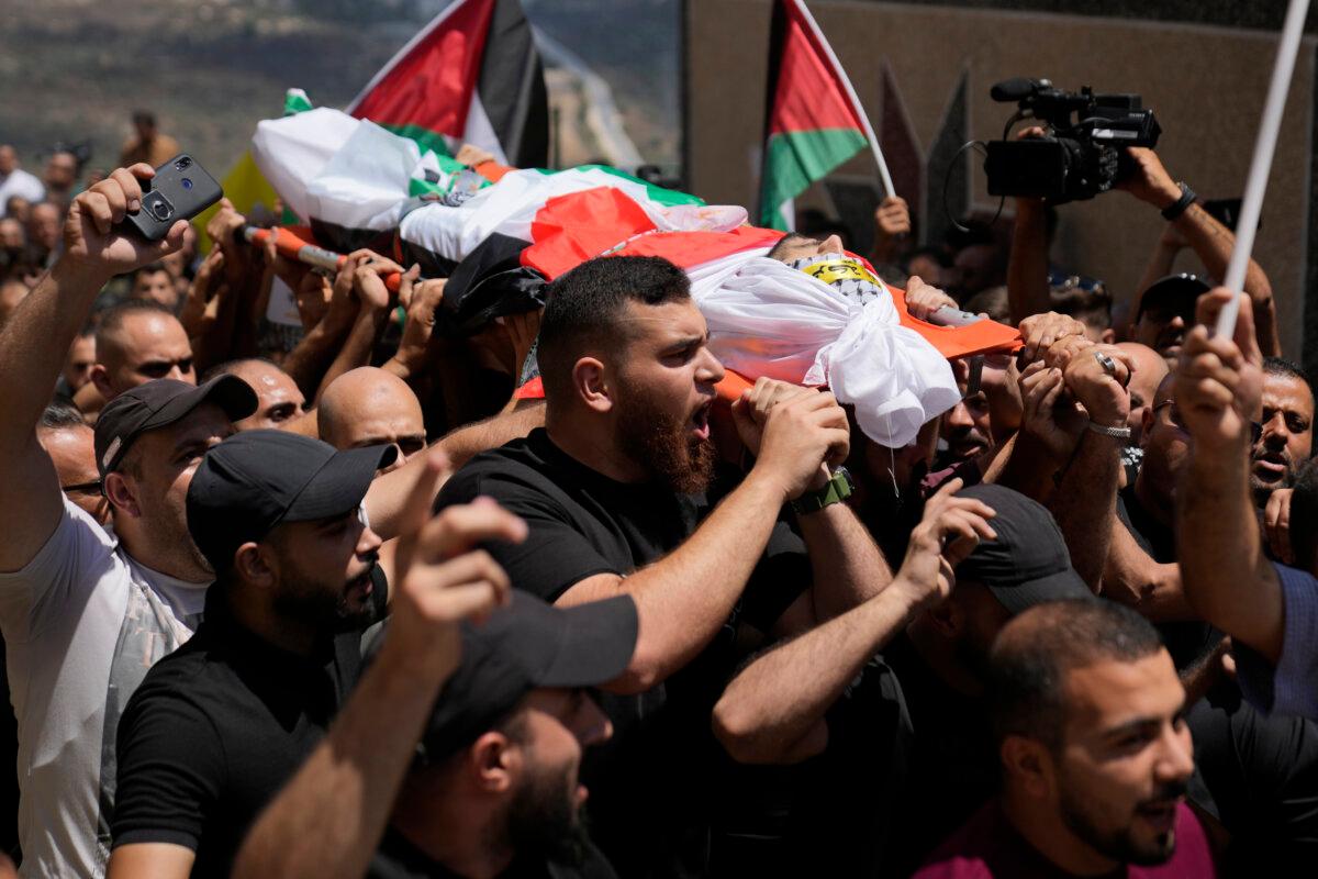 Mourners carry the body of Palestinian Rasheed Mahmoud Sadah, 23, who was killed during a rampage by Israeli settlers, during his funeral in the West Bank village of Jit, near Nablus, Aug. 16, 2024. (Nasser Nasser /AP Photo)