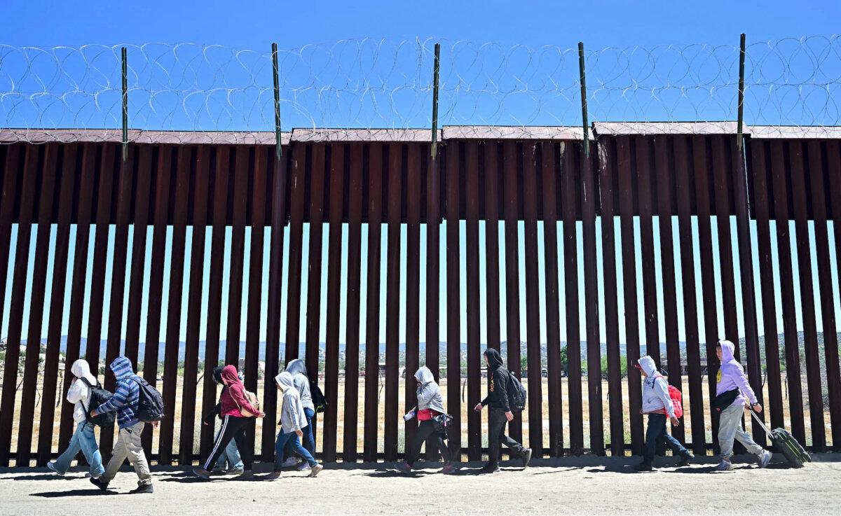 Immigrants Drive Job Growth as Native-Born Employment Drops, Data Shows | USNN World News Illegal immigrants walk on the U.S. side of the border wall in Jacumba Hot Springs, Calif., after crossing from Mexico on June 5, 2024. (Frederic J. Brown/AFP via Getty Images)