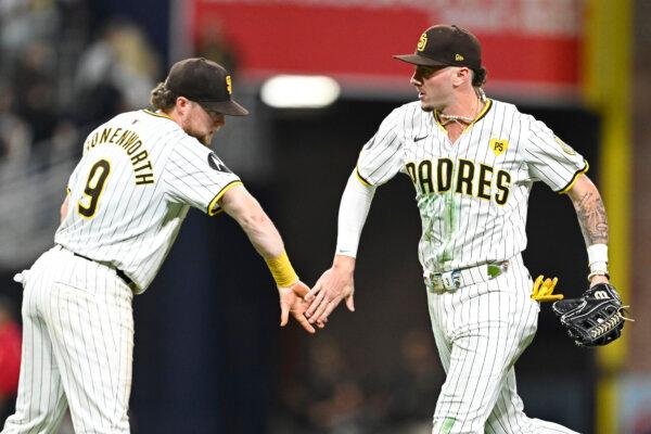 Jake Cronenworth, #9 of the San Diego Padres, and Jackson Merrill, #3, celebrate a 2–1 win over the Pittsburgh Pirates at Petco Park in San Diego on Aug 12, 2024. (Denis Poroy/Getty Images)