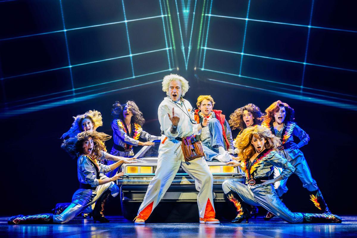 (L–R center) Doc Brown (Don Stephenson), Marty McFly (Caden Brauch), surrounded by the company of "Back to the Future: The Musical." (Matthew Murphy and Evan Zimmerman)