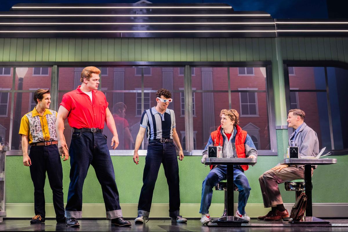 (L–R) Biff Tannen (Ethan Rogers), Marty McFly (Caden Brauch), George McFly (Burke Swanson), and the company of "Back to the Future: The Musical." (Matthew Murphy and Evan Zimmerman)