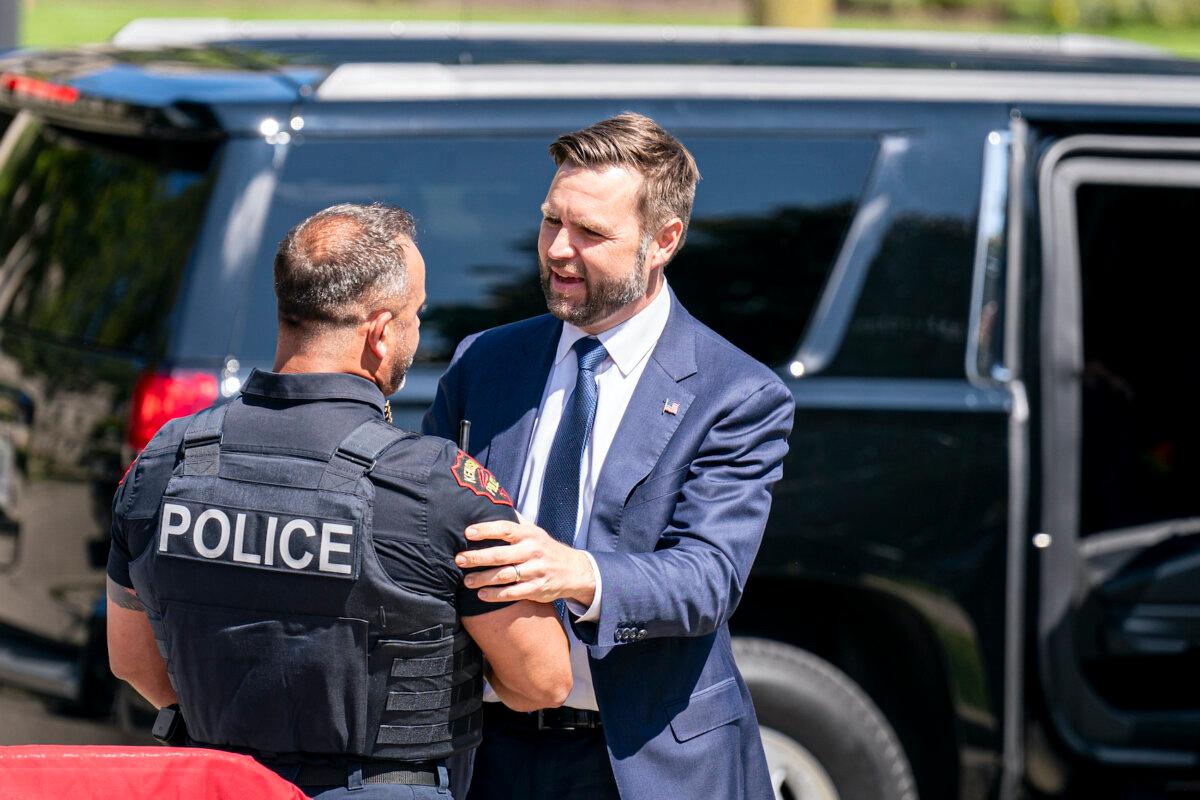 Republican vice presidential nominee Sen. J.D. Vance (R-Ohio) greets a police officer before a campaign rally in Kenosha, Wis., on Aug. 20, 2024. (Andy Manis/Getty Images)