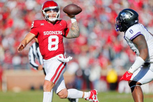 Quarterback Dillon Gabriel #8 of the Oklahoma Sooners throws the ball under pressure out of the pocket against linebacker Shad Banks Jr. #0 of the TCU Horned Frogs in the fourth quarter at Gaylord Family Oklahoma Memorial Stadium in Norman, Okla., on Nov. 24, 2023. (Brian Bahr/Getty Images)