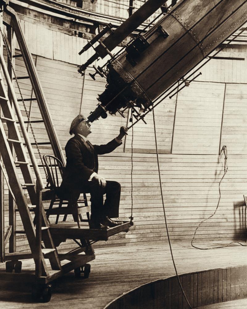 Percival Lowell observing planets with the 24-inch Alvan Clark & Sons refracting telescope at the Lowell Observatory in 1914. (Public Domain)