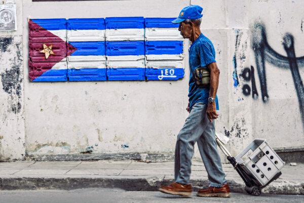 An elderly man passes by a wall with a Cuban flag painted on it in Havana on May 22, 2023. (Yamil Lage/AFP via Getty Images)