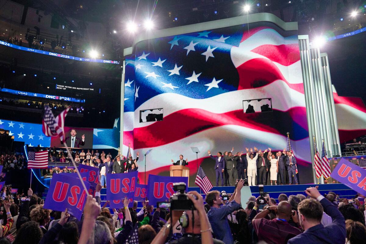 Democrat lawmakers onstage wave to the crowd during the last day of the Democratic National Convention in Chicago on Aug. 22, 2024. (Madalina Vasiliu/The Epoch Times)