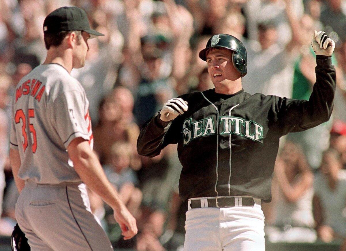 Seattle Mariner Dan Wilson (right) jumps up after stealing home plate despite efforts to cover the base by Baltimore Oriole pitcher Mike Mussina (left) in the eighth inning in Seattle on Aug. 1, 1999. The Mariners won 3-1. (Dan Levine/AFP via Getty Images)
