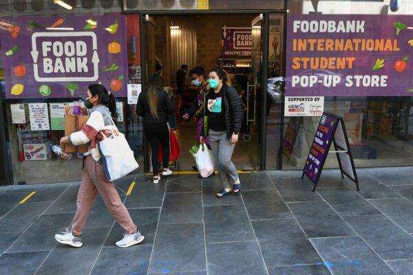 International students carry groceries from a foodbank in Melbourne, Australia, on Aug. 13, 2021. (William West/AFP via Getty Images)