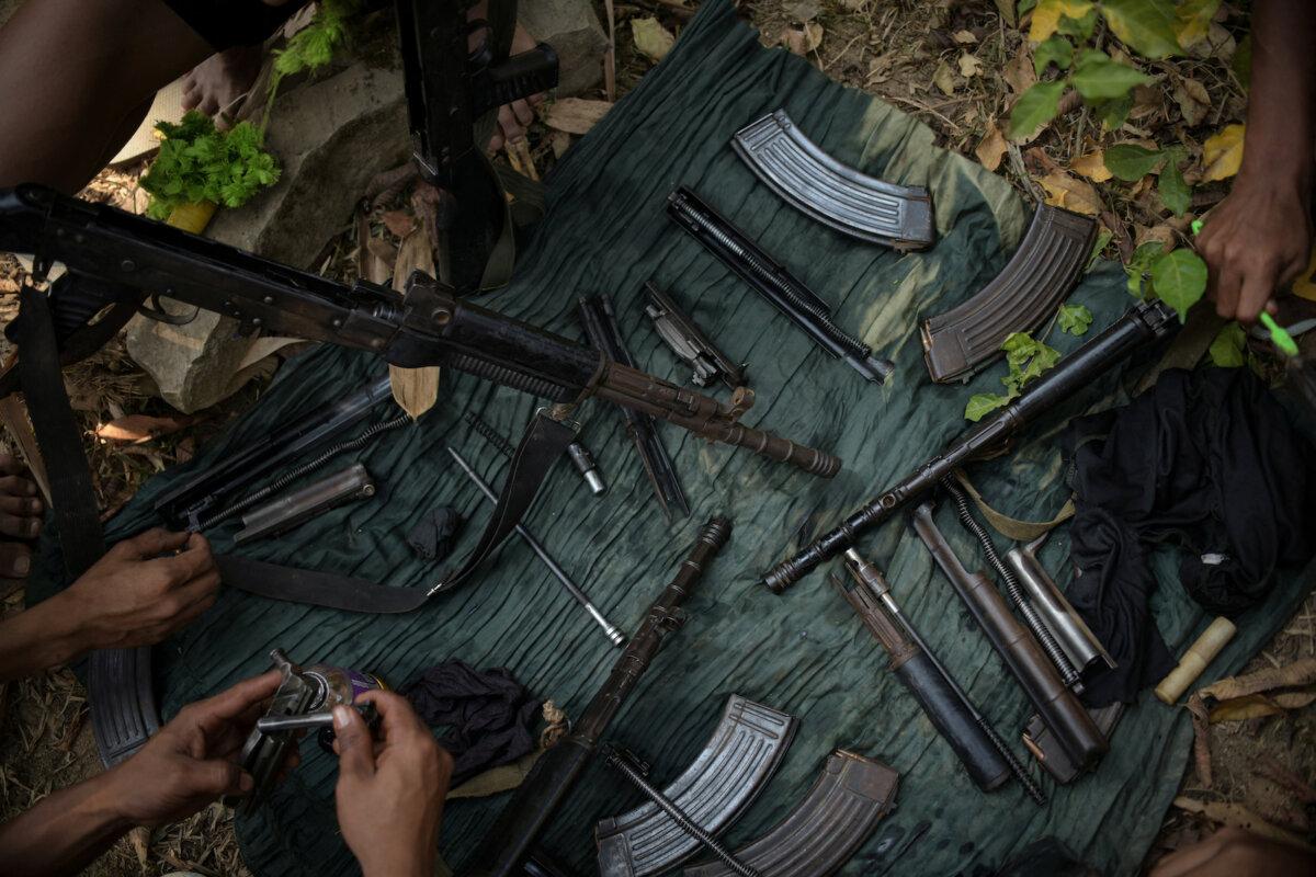 Members of Bamar People's Liberation Army clean their guns in territory belonging to the Karen National Liberation Army, in Karen State, Myanmar, on March 8, 2024. (Stringer/Reuters)