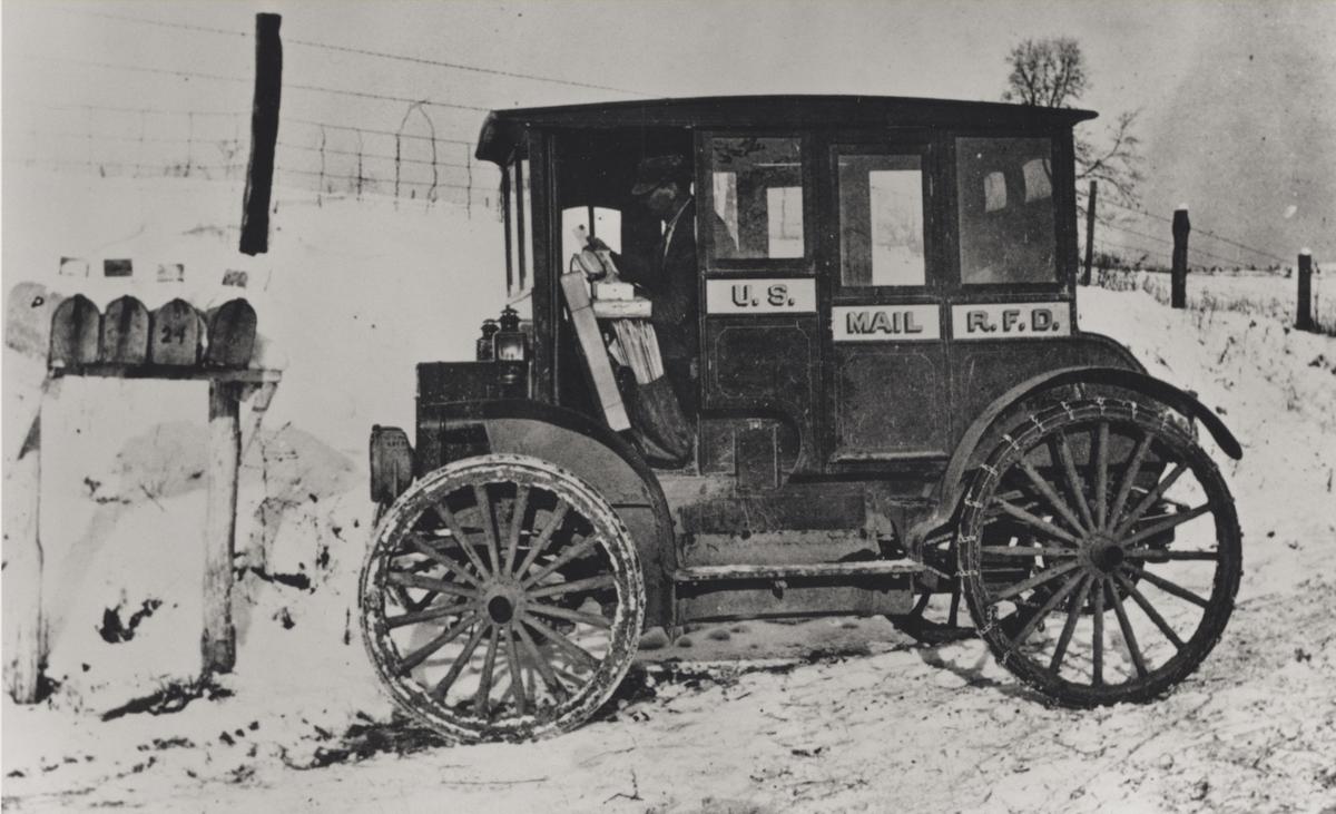 Rural carrier in an early electric vehicle, circa 1910. Smithsonian Institution. (Public Domain)