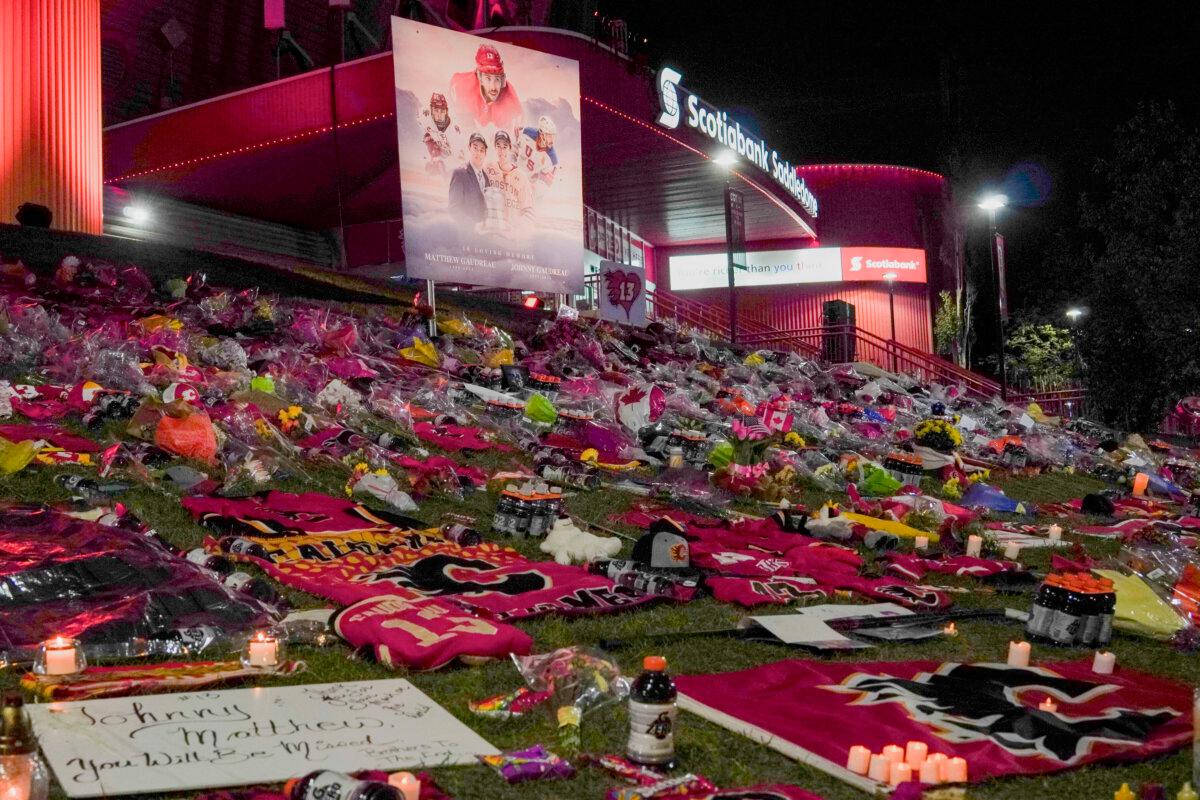 A makeshift memorial outside the Scotiabank Saddledome in honour of Johnny and Matthew Gaudreau featuring flowers, jerseys, purple Gatorade drink packets, Canadian flags, teddy bears, and bags of Skittles. Calgary Flames fans held a vigil in honour of the deceased brothers in Calgary on Sept. 4, 2024. (Carolina Avendano/The Epoch Times)