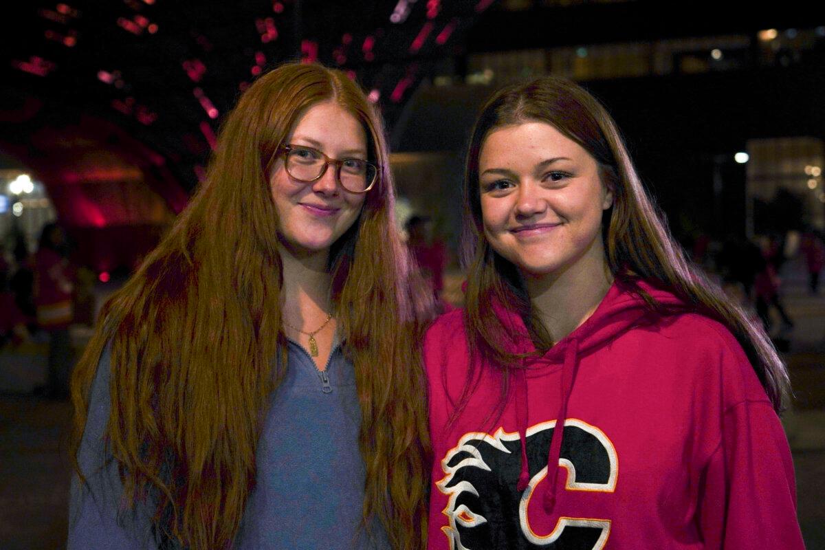 Paige Liebreich (L) and her friend Kyra MacDonald at the candlelight vigil honouring former Calgary Flames star Johnny Gaudreau and his brother Matthew outside the Scotiabank Saddledome in Calgary on Sept. 4, 2024. (Carolina Avendano/The Epoch Times)