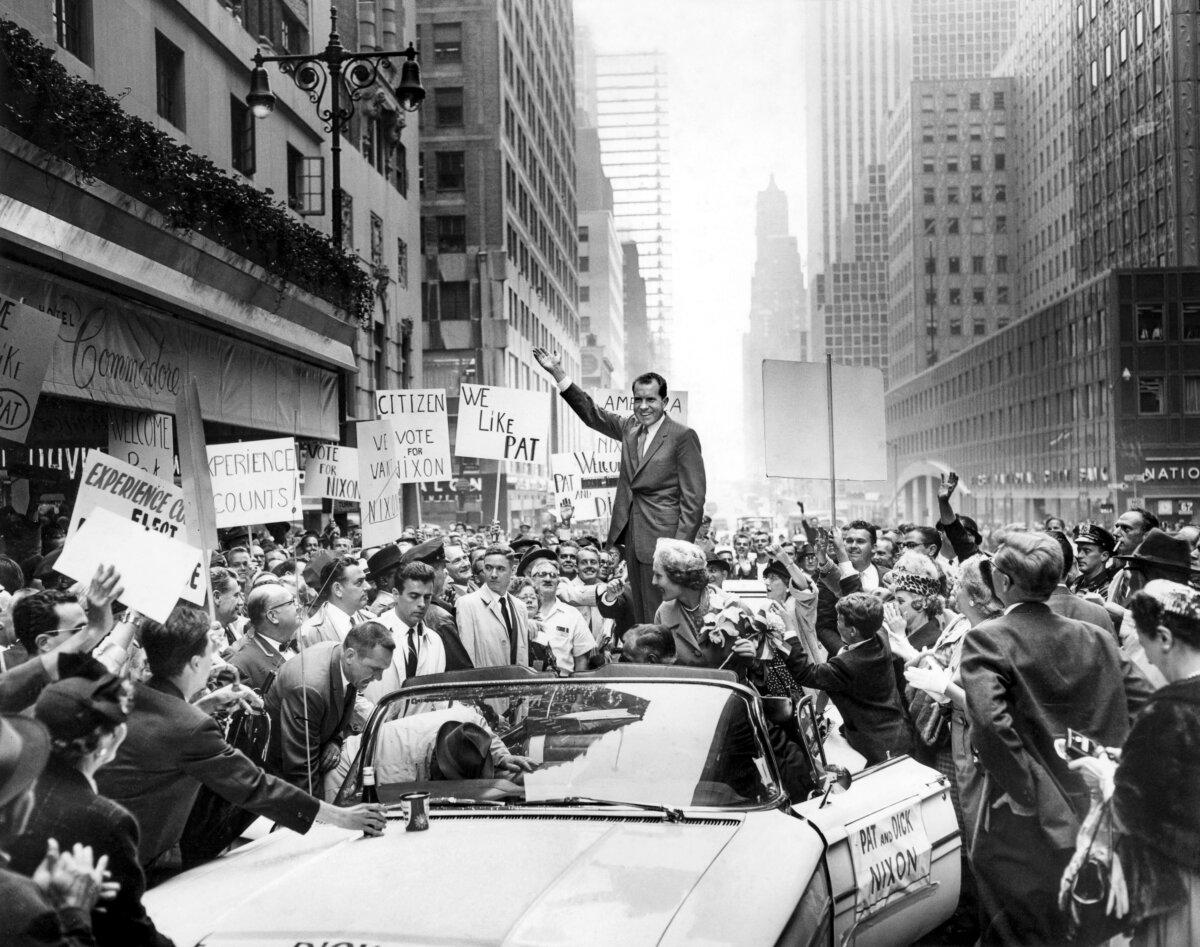 Vice-President and presidential candidate Richard Nixon (C) and his wife Pat (C bottom) wave to the crowd who gathered to see them leave the Commodore Hotel in New York City, on Sept. 28, 1960. (AFP via Getty Images)