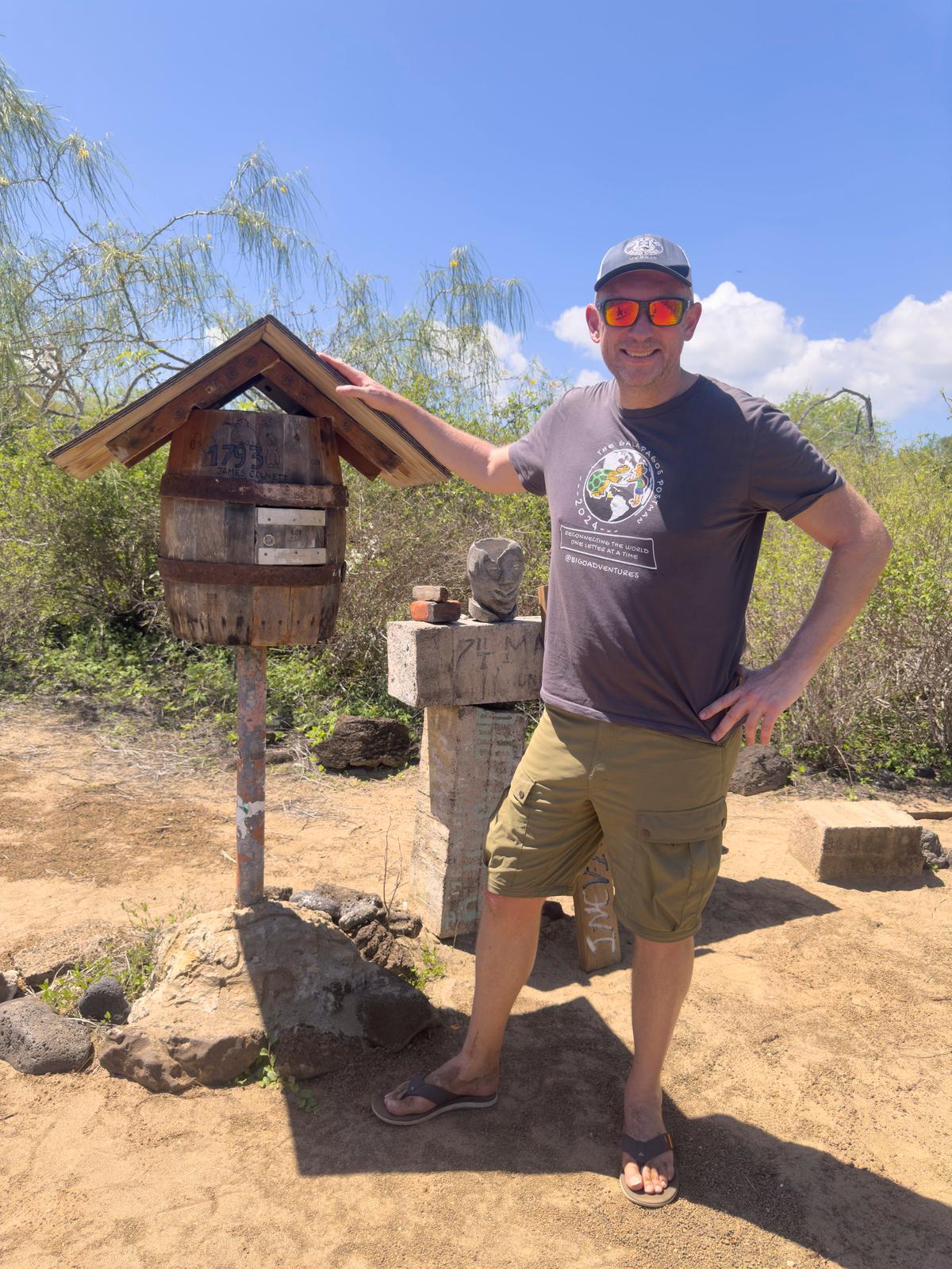Jonny Beardmore, 51, with the whisky-cask-turned-postbox in the Galapagos, where people drop postcards. (SWNS)