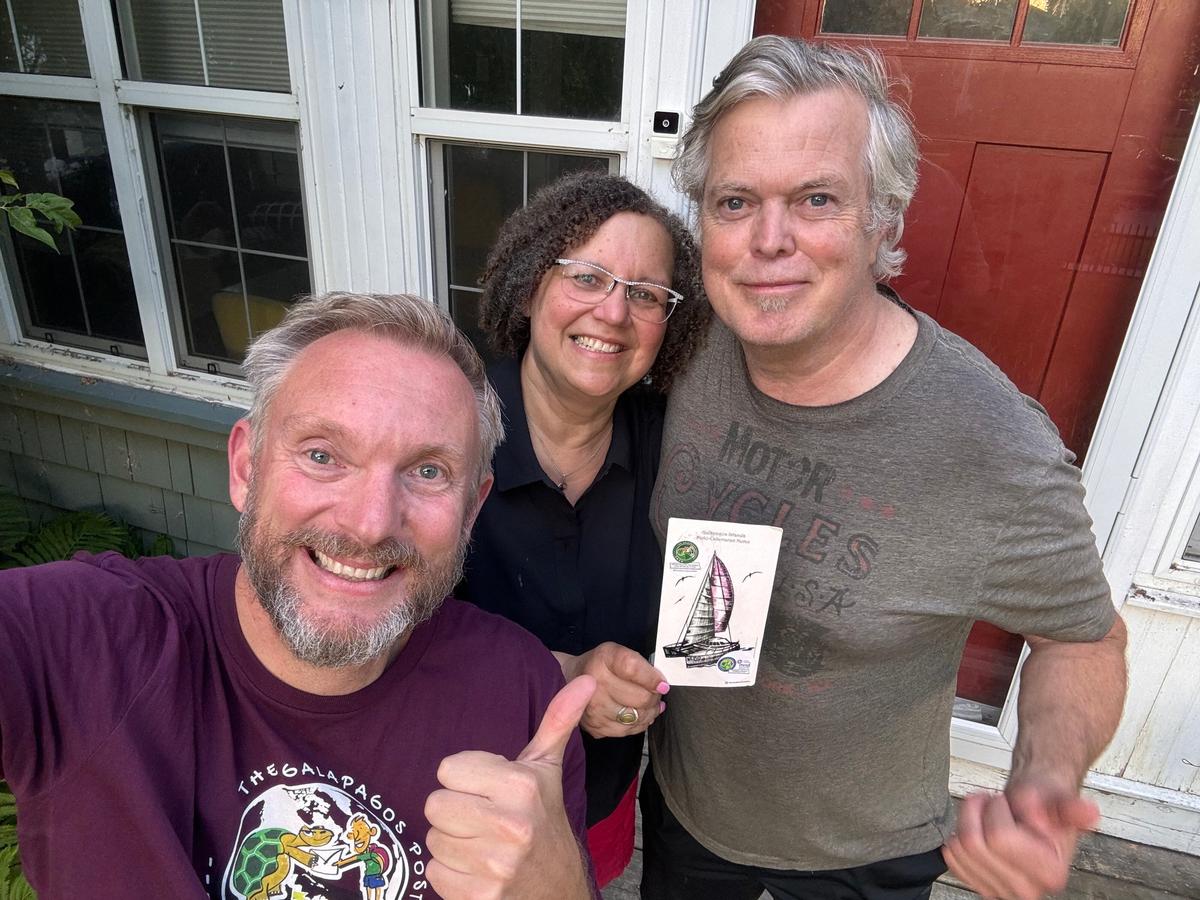 Galapagos postman Jonny Beardmore delivers a postcard to a resident in Winnipeg, Canada. (SWNS)