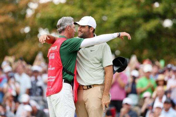 Scottie Scheffler of the United States celebrates with his caddie Ted Scott on the 18th green after winning during the final round of the TOUR Championship at East Lake Golf Club in Atlanta, Georgia, on Sept. 1, 2024. (Mike Mulholland/Getty Images)