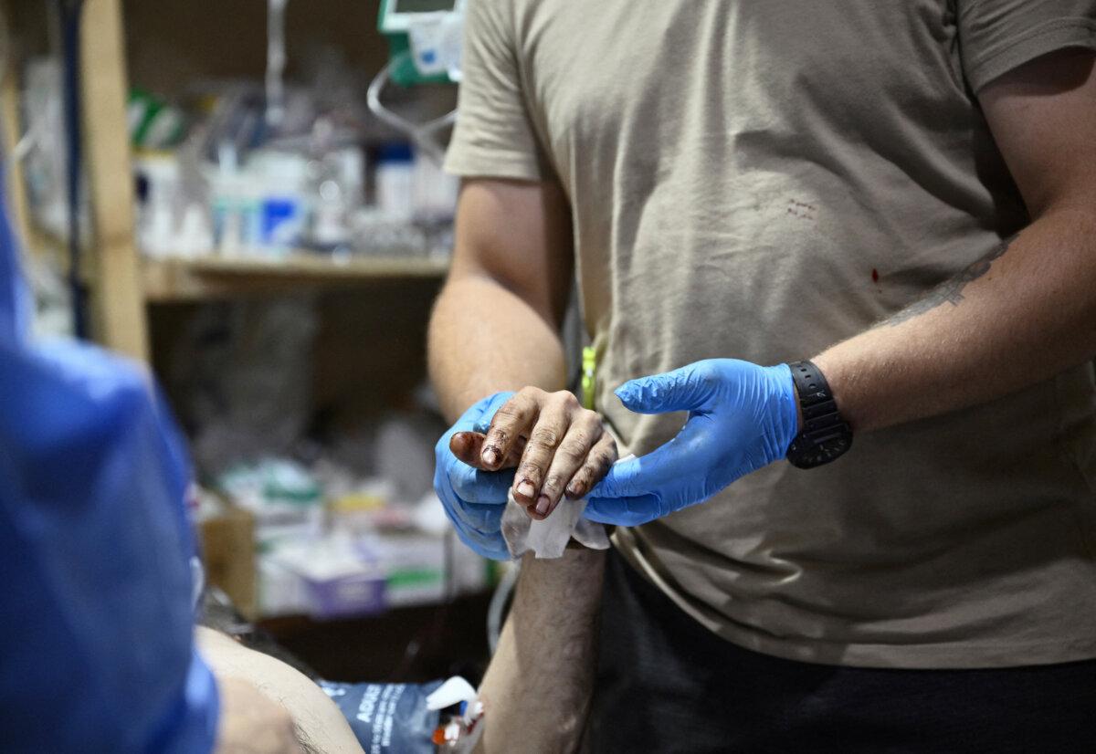 A medic from the Ukrainian army's 47th Mechanized Brigade treats a heavily wounded Ukrainian serviceman at a stabilization point in Pokrovsk, Donetsk region, on June 12, 2024. (Genya Savilov/AFP)