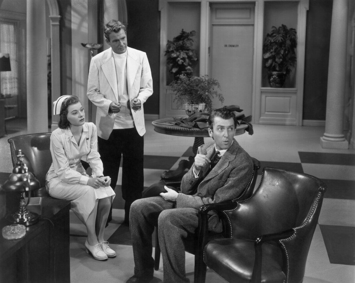 (L–R) A nurse (Peggy Dow) and a psychologist (Charles Drake) watch Elwood P. Dowd (James Stewart) talk to Harvey, in "Harvey." (MovieStillsDB)