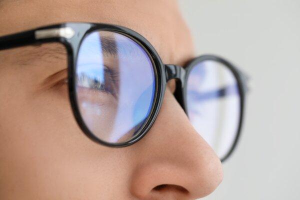 Vision correction. Man wearing glasses on blurred background, closeup (Shutterstock)