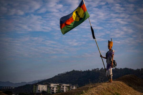 A woman with a traditional dress holds a Kanak flag in the Dumbea district of Noumea, in France's Pacific territory of New Caledonia on September 24, 2024. (Photo by SEBASTIEN BOZON/AFP via Getty Images)