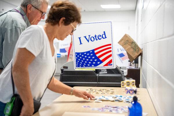 A woman picks up a sticker after voting at a polling station in Arlington, Va., on Sept. 20, 2024. (Andrew Harnik/Getty Images)