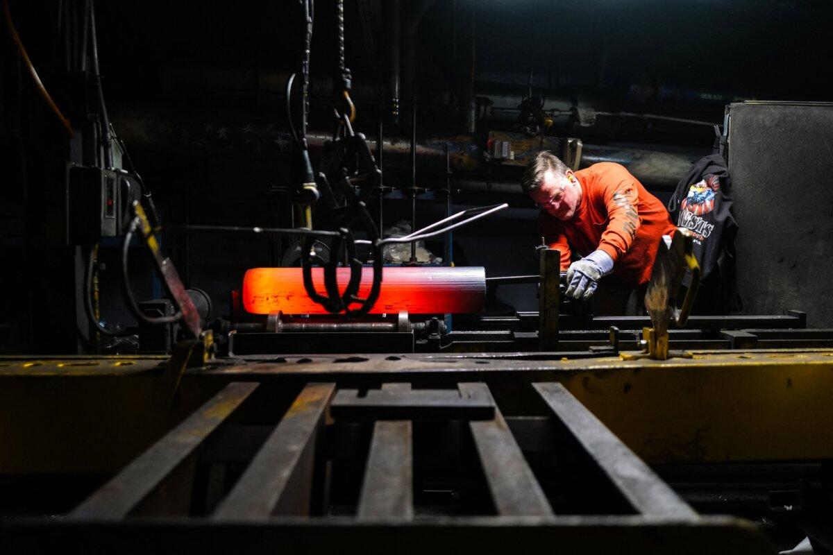 A worker inspects the form of the shaped steel billets following the "press" stage in the 155 mm caliber shells manufacturing process at the Scranton Army Ammunition Plant (SCAAP) in Scranton, Pennsylvania, on April 16, 2024. (Charly Triballeau/AFP)