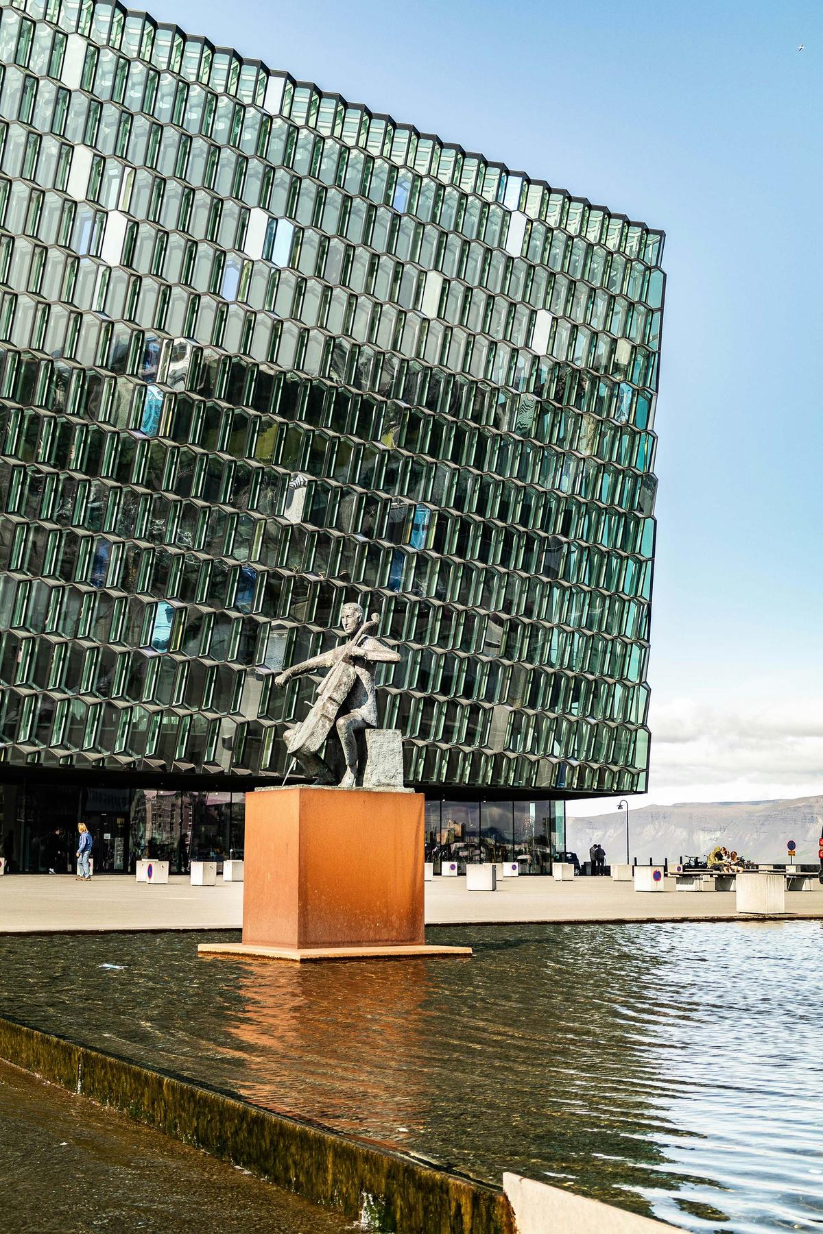 The iconic Harpa concert hall and "The Musician" sculpture that stands outside. (Michael Held/Unsplash)