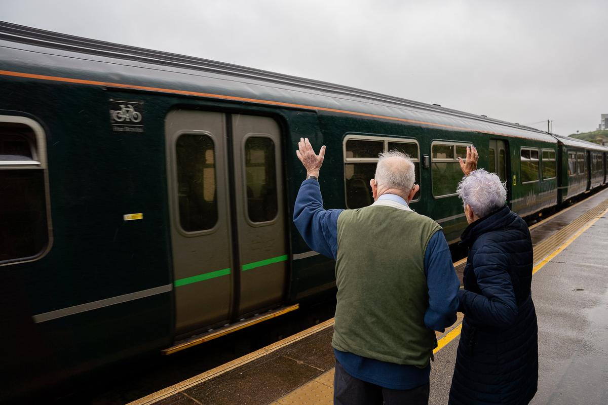 Margaret and George Stone waving off trains at Carbis Bay Station, Cornwall, on Sept. 5, 2024. (SWNS)