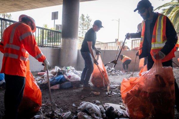 Gov. Gavin Newsom, center, helps clean up at a homeless encampment in Los Angeles County in August. (Gov. Gavin Newsom's Office)
