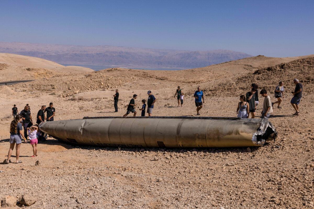People visit the site of the remains of an Iranian missile in the aftermath of an Iranian missile attack on Israel, in the Negev desert near Arad on Oct. 3, 2024. (Menahem Kahana/AFP)