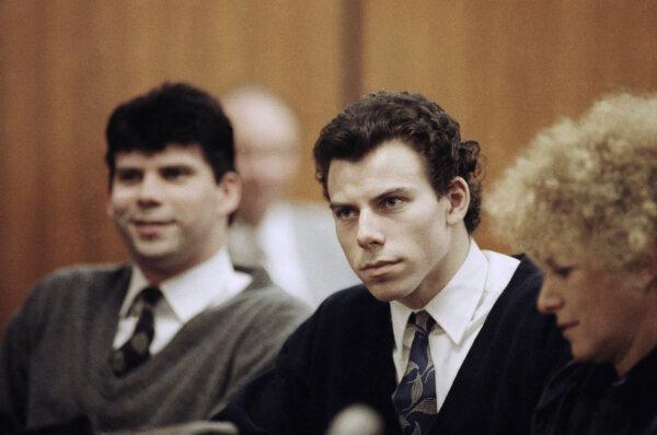 Lyle (L) and Erik Menendez sit with defense attorney Leslie Abramson (R) in Beverly Hills Municipal Court during a hearing on Nov. 26, 1990. (Nick Ut/AP Photo)