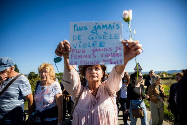 A woman holds a placard reading "No more Gisèle raped, no more women raped in France for 2025" during a march in support of her, in Mazan, France, on Oct. 5, 2024. (Clement Mahoudeau/AFP via Getty Images)