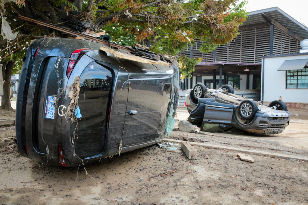 Overturned cars near a railway line in Biltmore Village, Asheville, N.C., on Oct. 3, 2024. (Richard Moore/The Epoch Times)