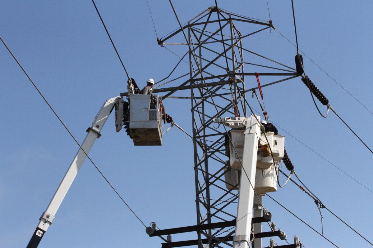 Linemen working in Biltmore Village, N.C., on Oct. 4, 2024. (Richard Moore/The Epoch Times)