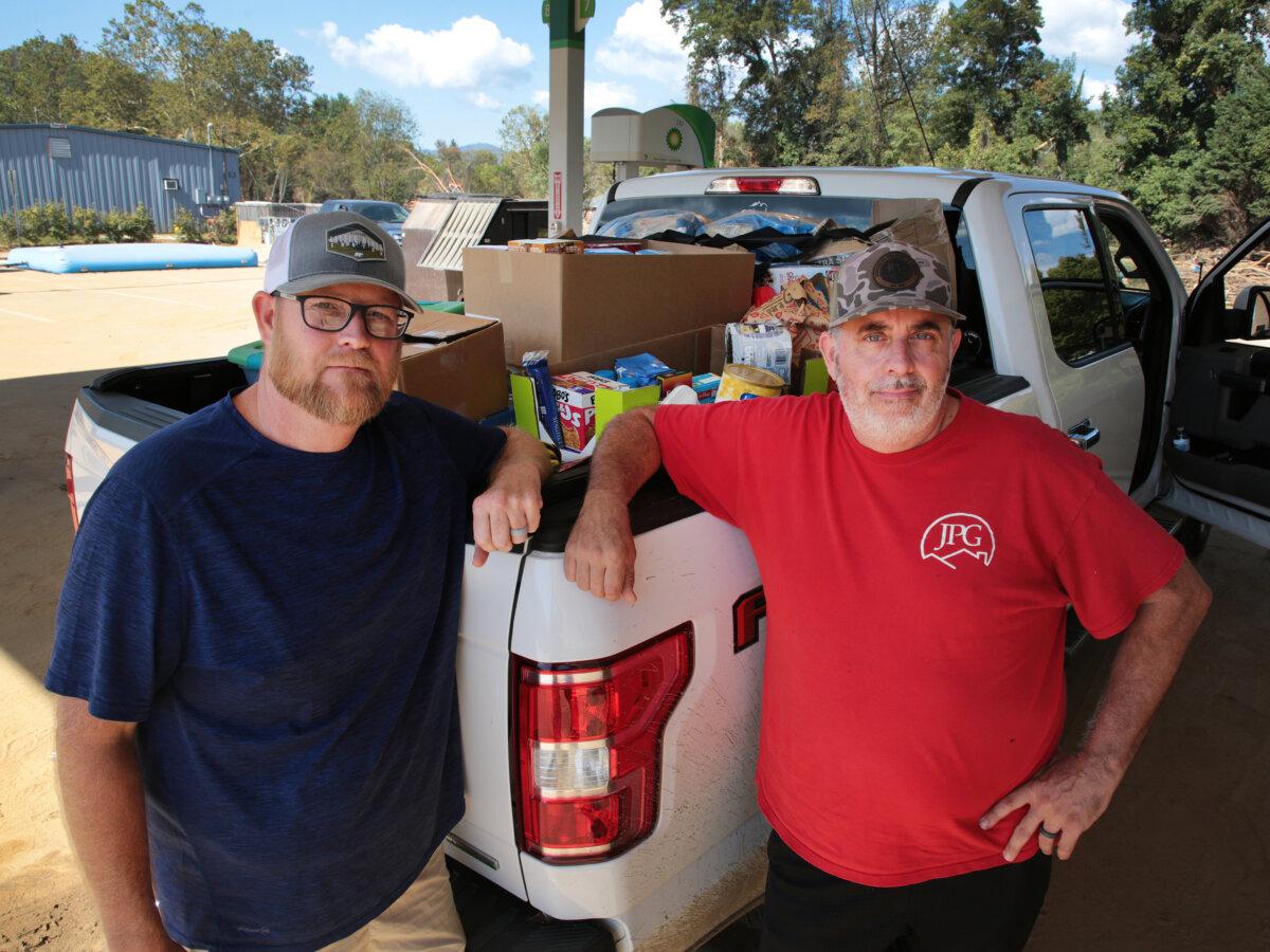 Brian Gray (L) and Chuck Johnson have been collecting and delivering goods to people in Swannanoa, N.C., since Hurricane Helene hit the area on Sept. 26. Photo taken on Oct. 4, 2024. (Richard Moore/The Epoch Times)