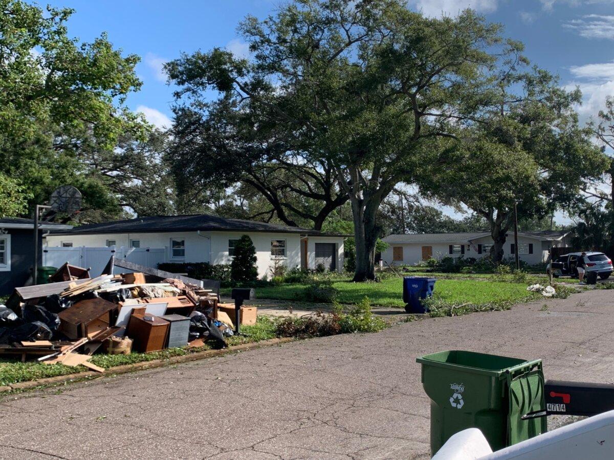 A pile of debris stands where it was next to Jason Burgess’s home (right) even after Hurricane Milton on Oct. 10, 2024. (T.J. Muscaro/The Epoch Times).