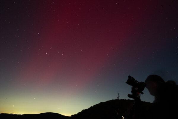 A photographer takes pictures of aurora borealis, or northern lights, produced by a solar geomagnetic storm, seen from Shenandoah National Park in Rileyville, Va., on Oct. 10, 2024. (Saul Loeb/AFP via Getty Images)