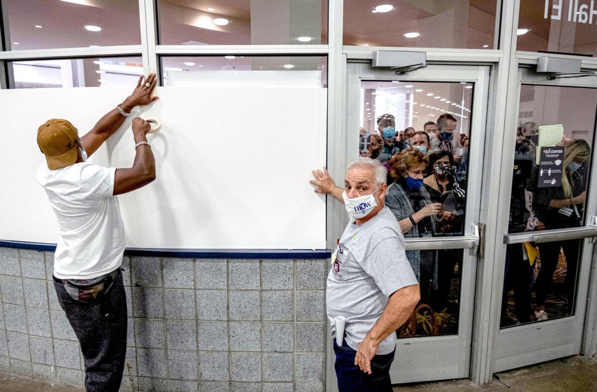 Poll workers board up windows of the ballot-counting area at the TCF Center in Detroit on Nov. 4, 2020. (Seth Herald/AFP via Getty Images)