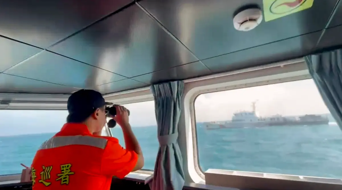 In this screen grab from video released by the Taiwan Coast Guard, a member of the Taiwan Coast Guard monitors a China Coast Guard boat as it passes near the coast of Matsu islands, Taiwan, on Oct. 14, 2024. (Taiwan Coast Guard via AP)