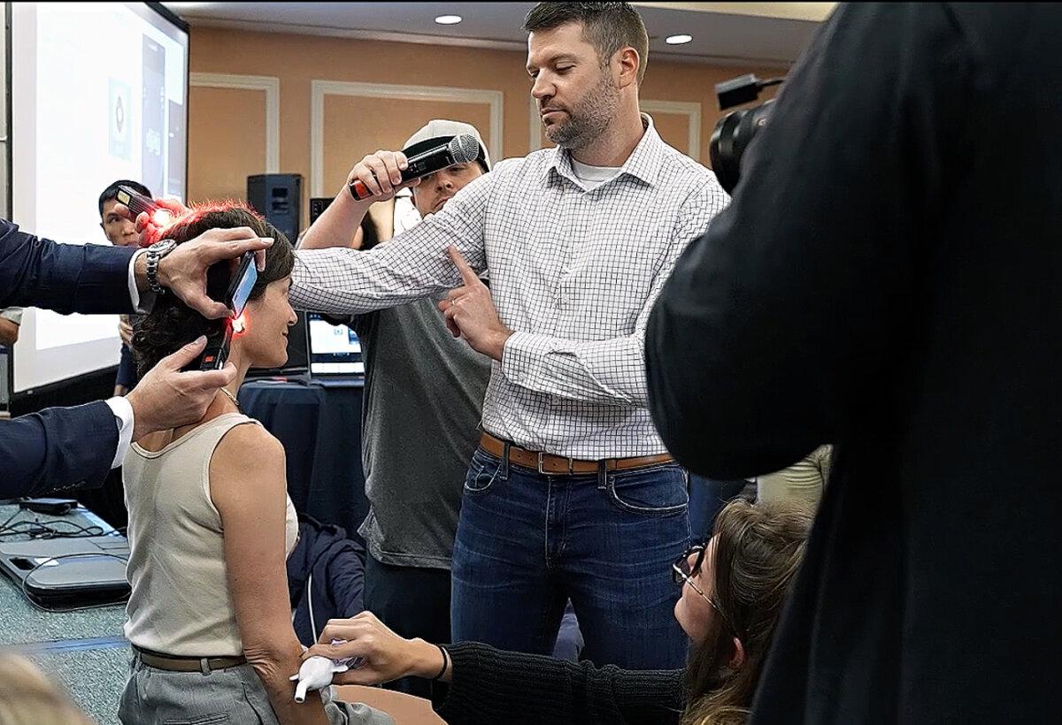 Crawford demonstrates light therapy on an adult. (Courtesy of Brandon Crawford)