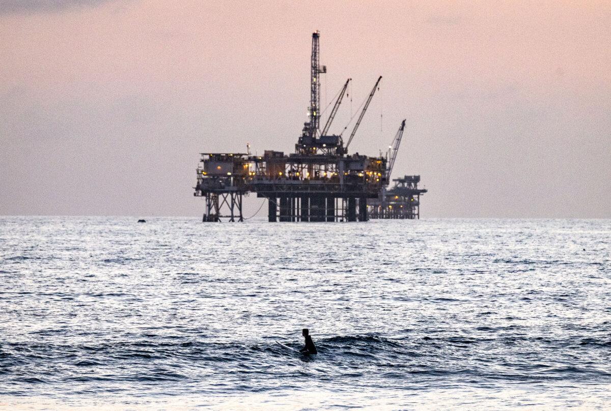 Tariffs Could Reduce Global Oil Demand, OPEC Says 2 Beachgoers enjoy the ocean in view of oil shipment and production vessels in Huntington Beach, Calif., on Sept. 12, 2024. (John Fredricks/The Epoch Times)