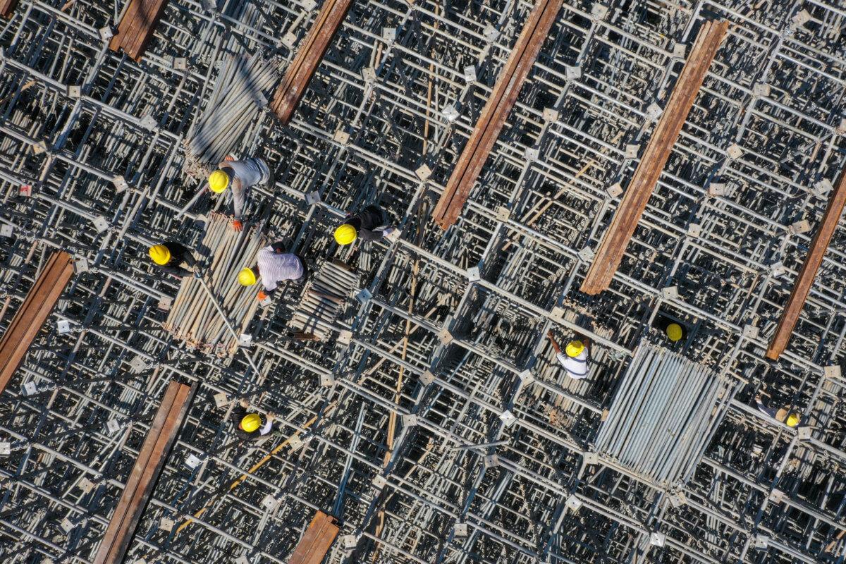 Workers on scaffolding at a highway bridge construction site in Shaoyang, in central China's Hunan province, on July 7, 2024. (STR/AFP via Getty Images)