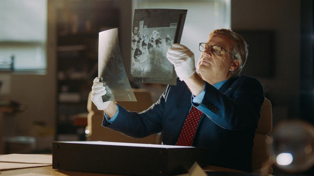Thomas Lynch, Boys Town Curator of the Archives, reviews images from the archives in "Heart of a Servant: The Father Flanagan Story." (Spirit Juice Studios)