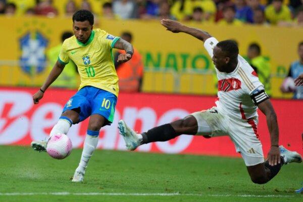 Brazil's Rodrygo, (L), is challenged by Peru's Luis Advincula during a qualifying soccer match for the FIFA World Cup 2026 at Mane Garrincha Stadium in Brasilia, Brazil, on Oct. 15, 2024. (Eraldo Peres/AP Photo)