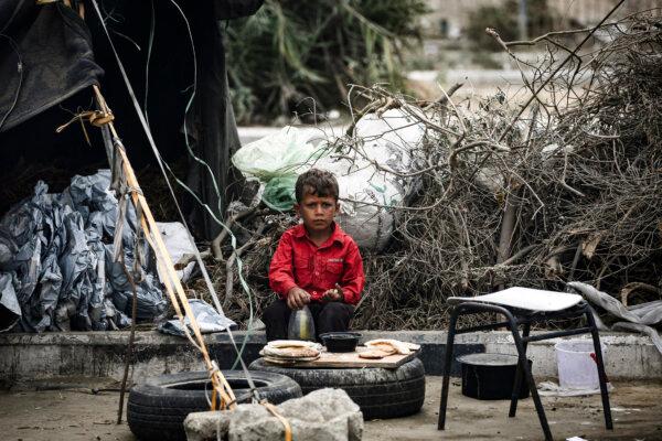 A Palestinian child eats at a makeshift camp for the internally displaced in Deir al-Balah, in the central Gaza Strip, on Oct. 17, 2024. (Eyad Baba/AFP via Getty Images)
