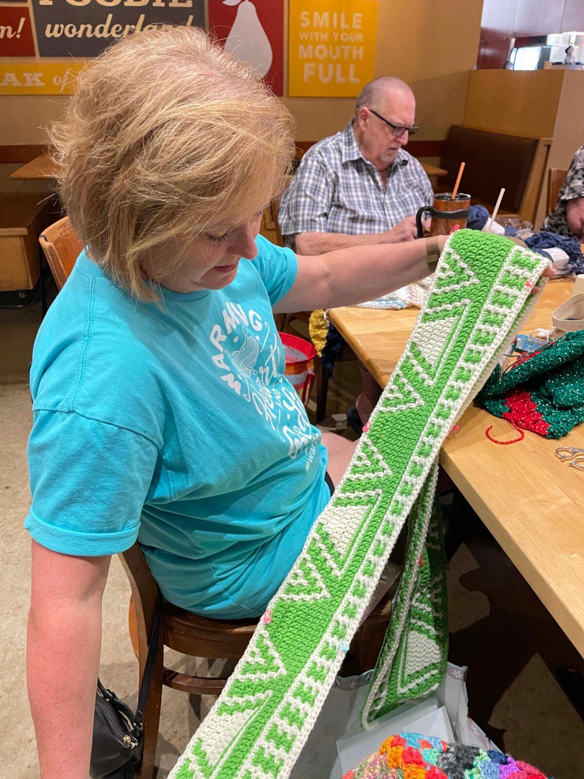 A volunteer shows off her crotcheted handiwork. (Hard Knoch PR)