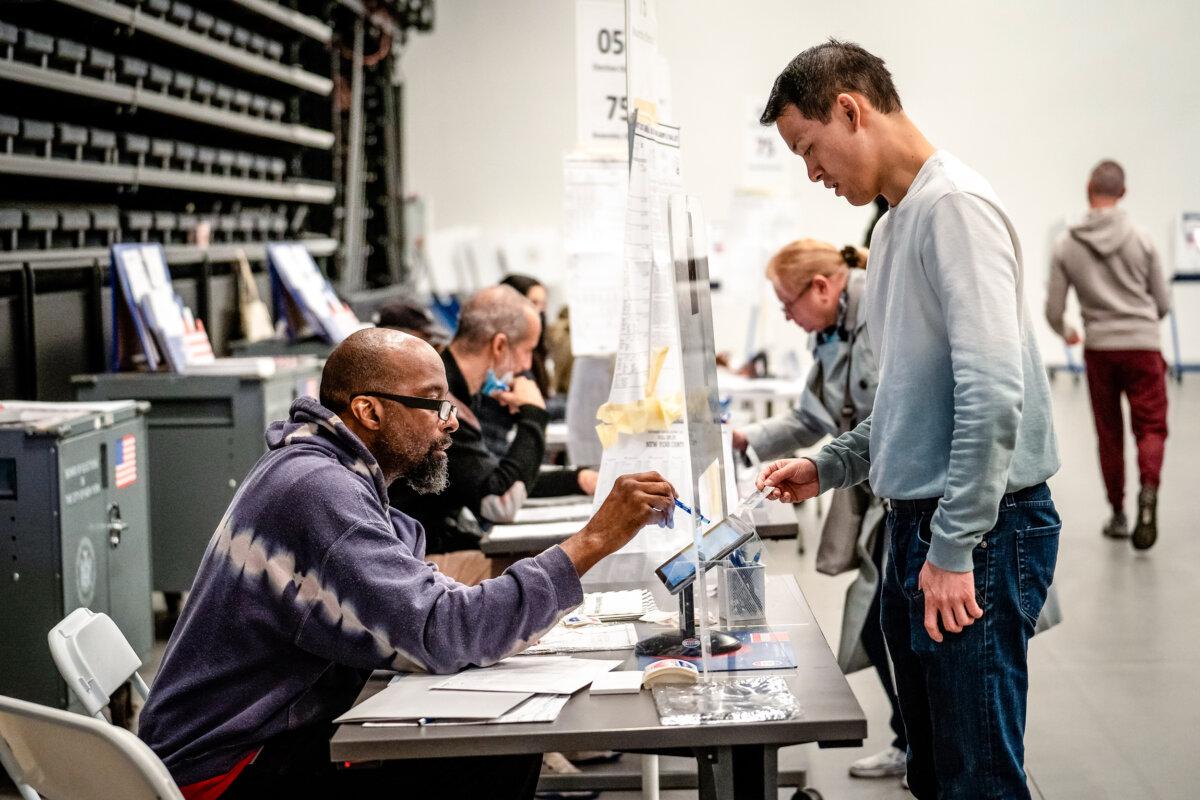 A voter shows his photo identification to poll workers as he arrives to cast his midterm election ballot in New York City on Nov. 8, 2022. (Samira Bouaou/The Epoch Times)