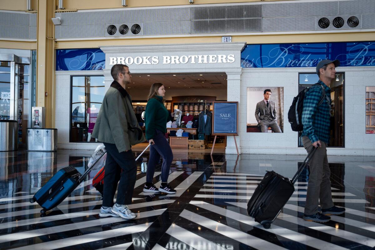 People walk by a store advertising sales at the Ronald Reagan Washington National Airport in Washington on Oct. 20, 2024. (Madalina Vasiliu/The Epoch Times)