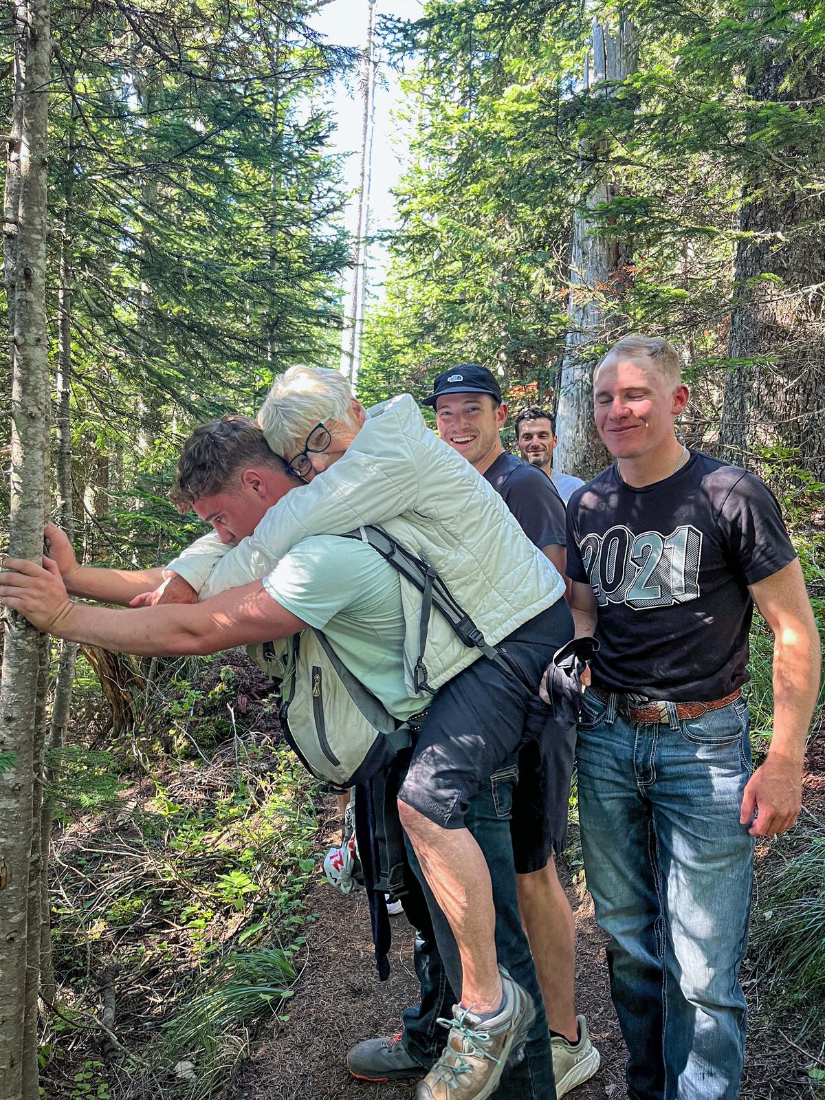 U.S. Air Force Airman 1st Class Troy May carries Ursula Bannister on his back on the High Rock trail near Ashford, Washington, on Aug. 28, 2024. (U.S. Air Force courtesy photo)